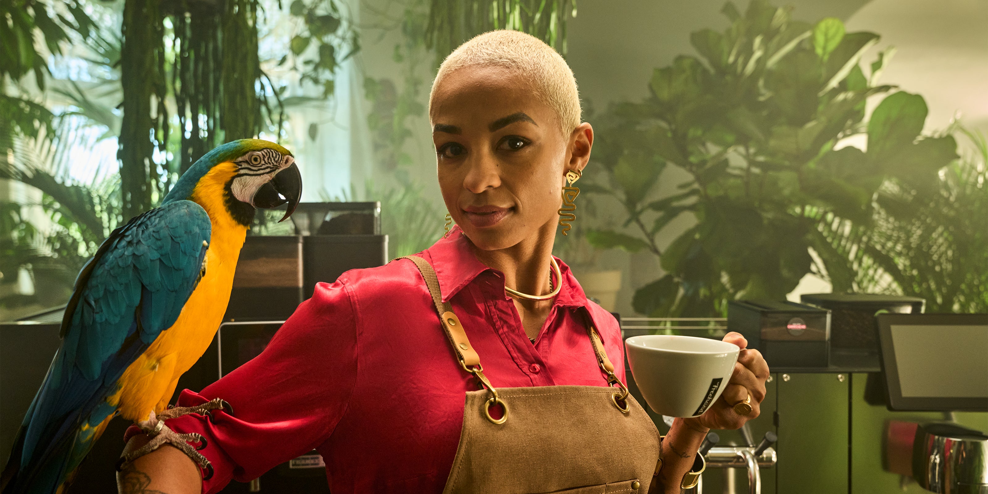 Kvinde med papeøje på armen og kaffekop i hånden